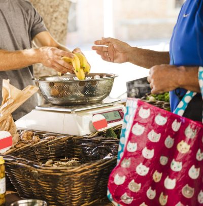 man-holding-bag-buying-bananas-from-fruit-seller-market